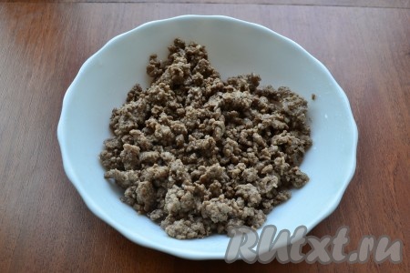 В сковороде разогреть растительное масло, добавить мелко нарезанный или натертый репчатый лук, добавить фарш, чуть посолить и обжарить все, помешивая, до готовности (минут 7-10). Фарш остудить до теплого состояния.
