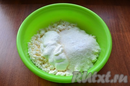 К творогу добавить сметану, всыпать сахар и ванилин.