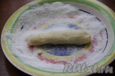 Это простое и быстрое печенье формируется без раскатки теста. На плоскую тарелку насыпаем 2-3 столовых ложки сахара. От теста отщипываем кусочек, формируем из него колбаску (можно сформировать тесто и в форме шариков или придать ему руками любую другую форму). Равномерно обваливаем эту колбаску из теста в сахаре со всех сторон. Аналогично формируем всё печенье.