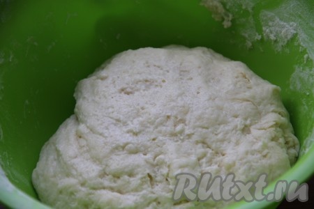 В получившуюся смесь всыпаем разрыхлитель, 1 столовую ложку сахара и начинаем частями всыпать муку. Вначале перемешиваем тесто ложкой, а когда оно начнёт собираться в ком, понемногу добавляя оставшуюся муку, замешиваем очень мягкое, воздушное тесто, которое будет слегка липнуть к рукам. Тесто должно быть именно немного липнущим, но лишнюю муку добавлять не нужно. При желании, чтобы проще было работать с тестом, можно просто слегка смазать руки растительным маслом.