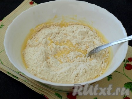 Далее ввести просеянную вместе с разрыхлителем муку и перемешать тесто ложкой.
