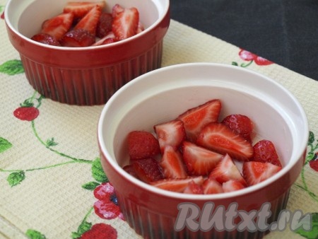 Формы для выпечки смазать сливочным маслом. Клубнику вымыть и обсушить, разрезать на 4 части. Разложить клубнику на дно форм.
