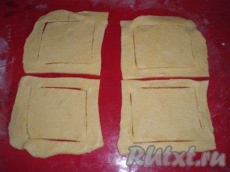 Слоеное тесто разморозить. Раскатать, поделить на квадраты одинакового размера (примерно 10х10 см).&nbsp;Каждый квадрат надрезать с противоположных углов.