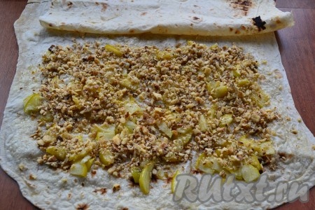 Выложить на 2/3 длины лаваша остывшие яблоки, сверху посыпать орехами.