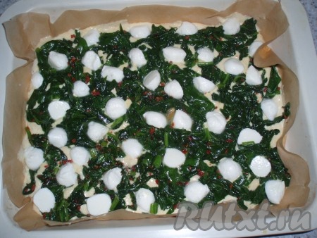 По тесту равномерно распределить шпинат, разложить кусочки сыра.
