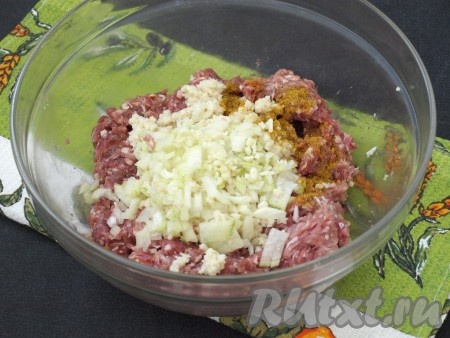 Далее булочку размять и добавить в фарш. Мелко нарезать лук и чеснок, также добавить их к мясному фаршу, посыпать приправой карри.
