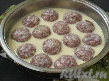 Выложить в получившийся молочный соус тефтели, прокручивая так, чтобы они сверху были покрыты соусом. Сковороду накрыть крышкой, огонь сделать минимальным и готовить тефтели 10 минут, затем открыть крышку и снова перевернуть тефтели другой стороной, готовить ещё 20 минут.
