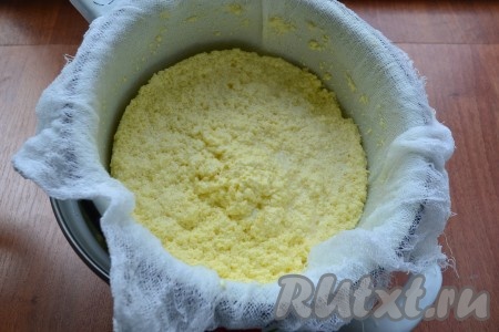 Марлю, сложенную вдвое или втрое, поместить в дуршлаг и отцедить творог от сыворотки.
