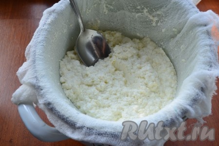 Отцедить горячий творог от сыворотки через 2 слоя марли. Перемешивать творог в марле до тех пор, пока не стечет вся сыворотка.
