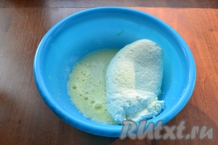 В яичную смесь выложить отцеженный и отжатый мягкий творог.