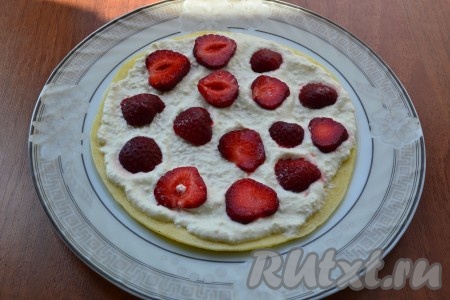 Взбить творог со сметаной и сахаром погружным блендером до однородности. Далее каждый теплый блин смазать творожной массой, разложить клубнику и выкладывать блины друг на друга, собирая блинный торт.
