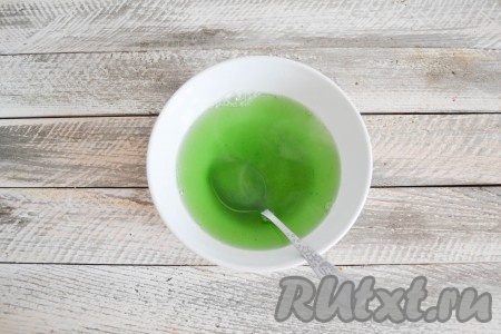 Для подготовки следующего слоя в миску всыпать один пакетик желе со вкусом киви и залить 300 мл кипятка, перемешать до однородности.
