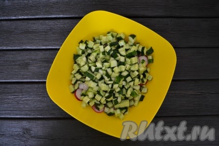 Огурец нарезать мелкими кубиками и соединить в глубокой миске с редисом.
