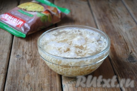 Залить кипятком так, чтобы он полностью покрывал лапшу. 