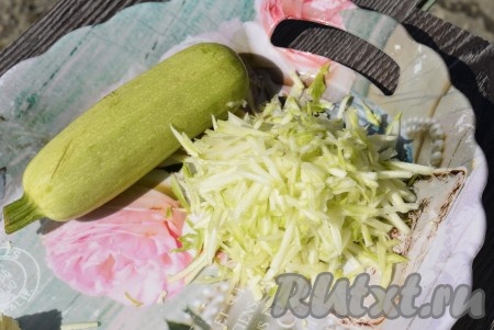 Пока капуста остывает и с нее стекает лишняя влага, кабачок, очищенный от кожуры, натереть на крупной тёрке, посолить и оставить на 5 минут, чтобы он пустил сок.
