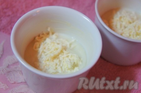 Жаропрочные керамические формочки (я взяла 2 формочки) смазать сливочным маслом, равномерно разложить по ним смесь цветной капусты и молока, добавить немного натёртого сыра.
