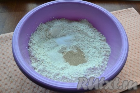 В муку добавить соль, сахар и сухие дрожжи, перемешать.
