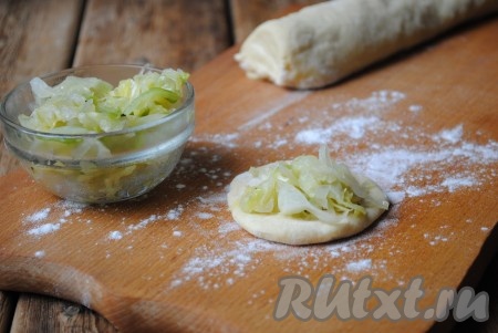 Тесто разделить на несколько частей. Из каждой части скатать колбаску. На столе, присыпанном мукой, каждую колбаску нарезать на небольшие кусочки. Каждый кусочек теста раскатать в лепёшку, на которую выложить небольшое количество начинки (примерно, 1 чайную ложку). 