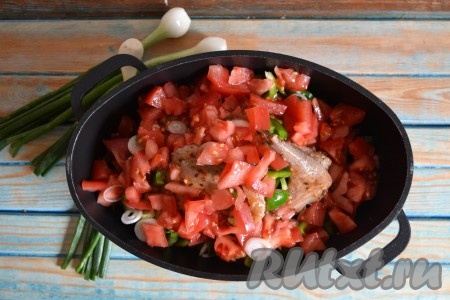 Вымытые помидоры нарезать мелкими кубиками и также всыпать в казан к мясу кролика. Влить воду и поставить на слабый огонь. Тушить при плотно закрытой крышке 30-40 минут.
