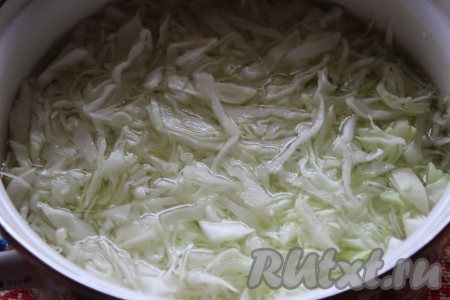 Затем поместить нашинкованную капусту в кастрюлю с кипящей водой и проварить 5 минут на небольшом огне. Если вы используете молодую капусту - то её варите 1-2 минуты.
