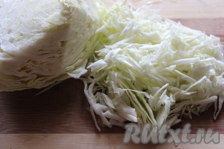 В кастрюлю подходящего размера налить холодную воду и довести ее до кипения. Тем временем, сняв верхние листы с кочана капусты, промыть кочан под проточной водой и тонко нашинковать.
