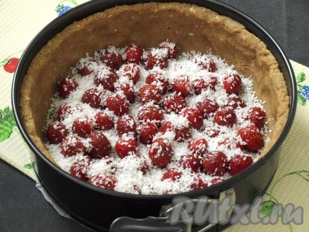 Вымыть клубнику и промокнуть лишнюю влагу. Достать из холодильника форму, на дно выложить клубнику. Несколько ягод можно оставить для украшения. Посыпать клубнику кокосовой стружкой (если нет стружки, то можно обойтись и без нее).
