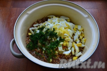 Очищенные вареные яйца нарезать довольно крупно и добавить их в гречку вместе с измельченной зеленью.
