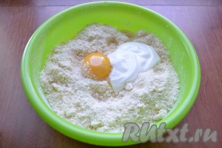 Все перетереть руками в мелкую крошку. Добавить сырой желток и сметану.