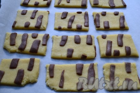 Скалкой или руками вдавить темные полосочки в светлое тесто. Затем нарезать тесто на прямоугольники или квадраты, выложить их на противень, застеленный пергаментом.
