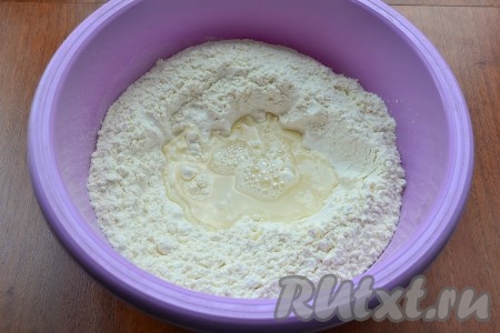 Муку просеять в миску, сделать углубление. Влить частями солёную воду, каждый раз полностью вмешивая её. Вначале перемешивать тесто столовой ложкой, а после того как тесто начнёт собираться в ком, продолжать замешивать руками.