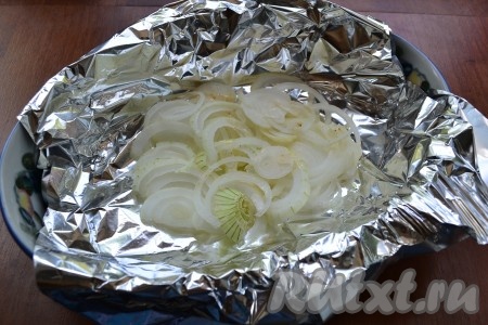 В форму для запекания поместить лист фольги, сложенный вдвое. Лук репчатый нарезать кольцами или полукольцами и разместить на дне фольги.
