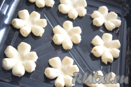 Выложить получившиеся булочки-цветочки на противень, смазанный растительным маслом.&nbsp;Серединку теста вдавить ручкой от скалки.
