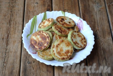 Обжаренные кабачки выложить на бумажное полотенце, чтобы убрать излишки растительного масла. Постепенно обжарить все кружочки кабачков.