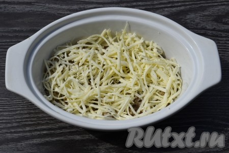 Посыпать фарш 100 граммами натёртого сыра.