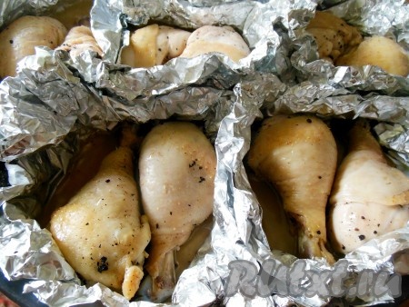 Достаньте противень из духовки и разверните каждый конвертик из фольги, чтобы куриные ножки смогли в дальнейшем подрумяниться.