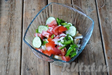 В миску с чесночными сухариками добавить помидоры, огурцы, перец и лук.&nbsp;