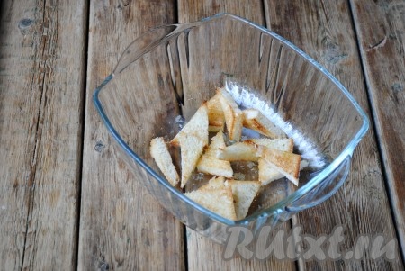 Выложить обжаренный хлеб в миску и залить чесночным маслом. Аккуратно перемешать&nbsp;для равномерного распределения ароматного масла по всем сухарикам, дать немного остыть.