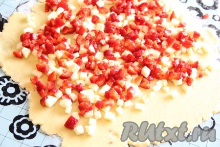 На раскатанное тесто, немного отступив от краёв, выложить клубнику и яблоки, по желанию, присыпать корицей.