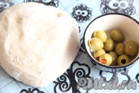  Готовое тесто ещё раз обмять, оливки откинуть на дуршлаг и дать стечь жидкости.