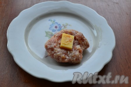 Фарш тщательно вымешать и отбить. Формировать мокрыми руками тефтели (довольно крупные), в середину каждой поместить по кубику твердого сыра.