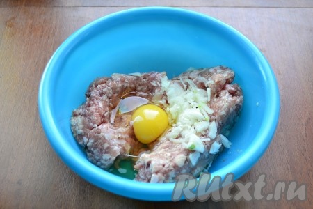 К фаршу добавить мелко нарезанный репчатый лук и сырое яйцо.