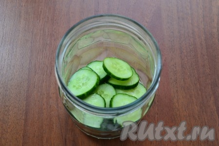 Следующим слоем расположить свежие огурцы, нарезанные кружками.
