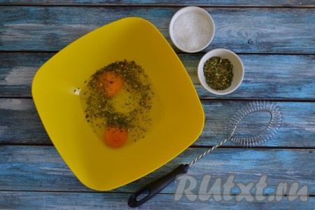 Для приготовления кляра в глубокую миску вбить два куриных яйца, всыпать соль и прованские травы.