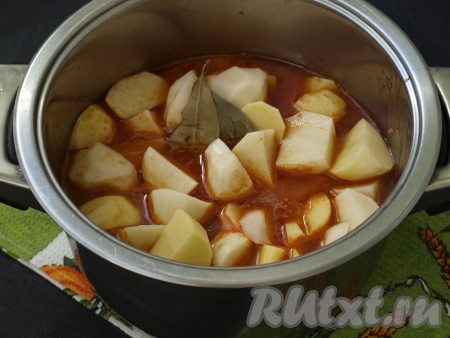 Если говядина легко прокалывается вилкой - то можно добавлять картофель, лавровые листья и около стакана воды. Накрыть кастрюлю крышкой и тушить 25 минут.
