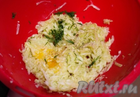 Образовавшуюся жидкость слить, кабачок отжать, добавить черный молотый перец, яйцо, мелко нарезанную зелень, перемешать.