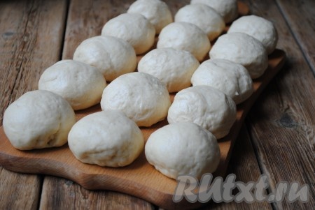 Готовое дрожжевое тесто разделить на 20 равных частей. Из каждой части теста скатать небольшой шарик. Накрыть их полотенцем и дать отдохнуть 5 минут. 