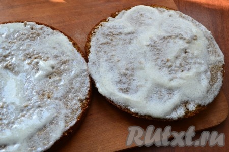 Разрезать пирог на 2 части. Каждую часть хорошенько (2 раза) промазать сметанным кремом.