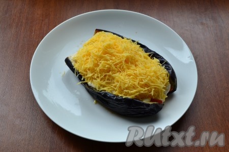 Сверху внутренность баклажана щедро посыпать оставшимся натёртым сыром.