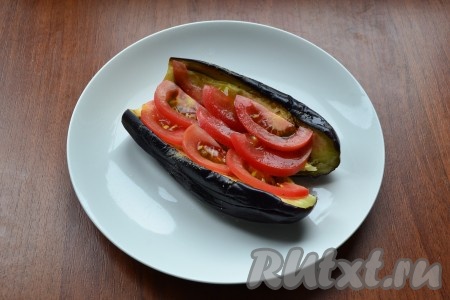 Внутрь баклажана поместить тонкие дольки свежего помидора.
