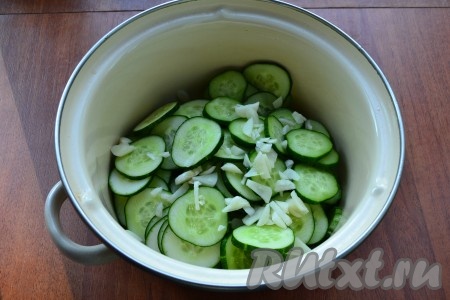 В миску или кастрюлю нарезать огурцы тонкими кружочками, добавить измельченный чеснок.
